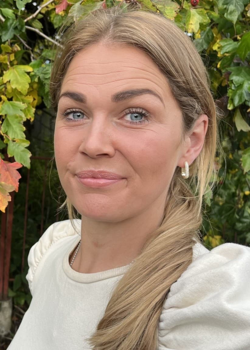 Hanna Edwardsson står framför en buske med gulnande löv.