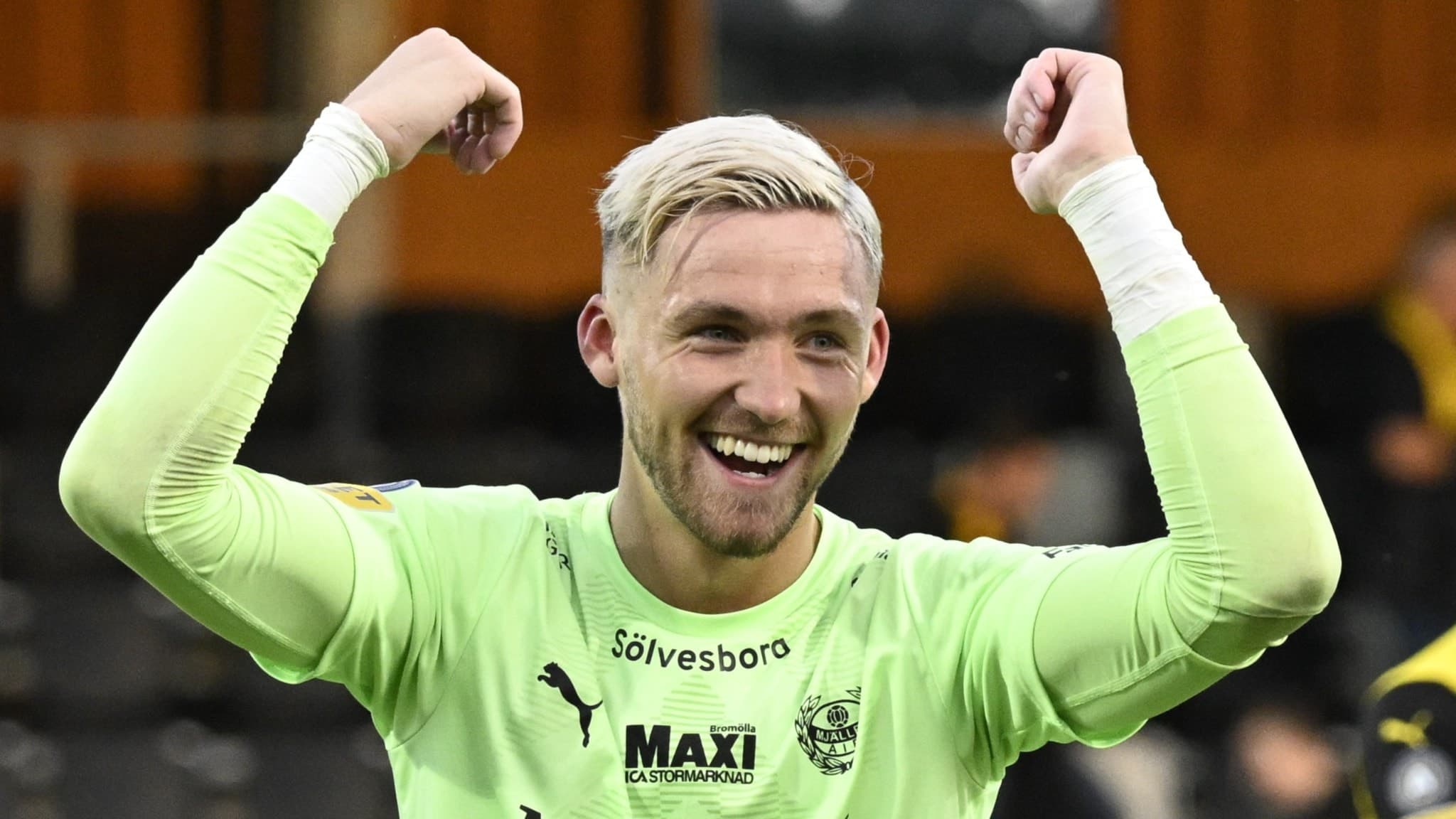 Mjällbys målvakt Noel Törnqvist firar med uppsträckta armar efter seger i en allsvensk fotbollsmatch mot Halmstad BK på Strandvallen i Hällevik. Han bär en grön målvaktströja.