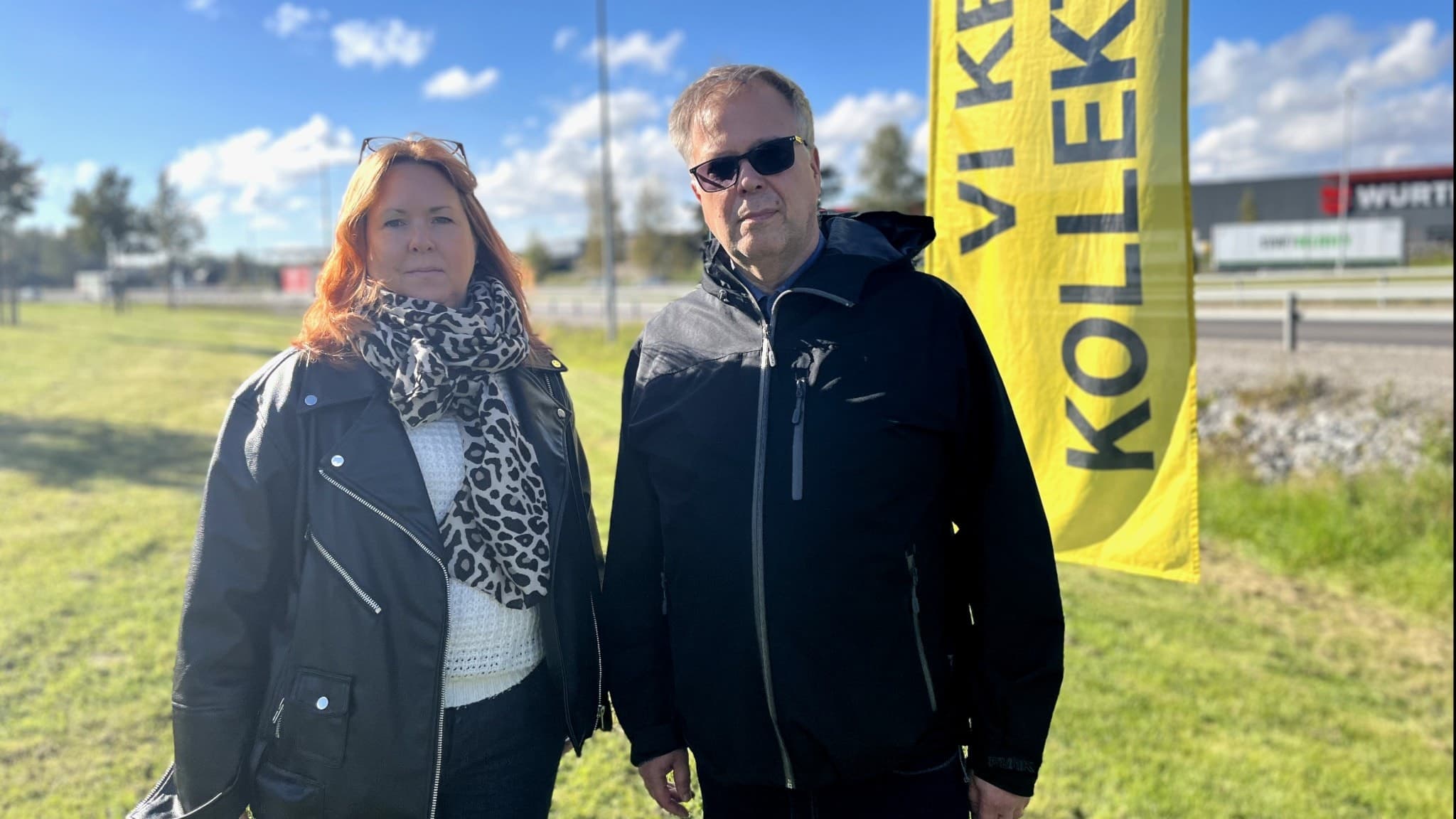 Inga Vintervärn och Tomas With står utomhus framför en gul flagga.
