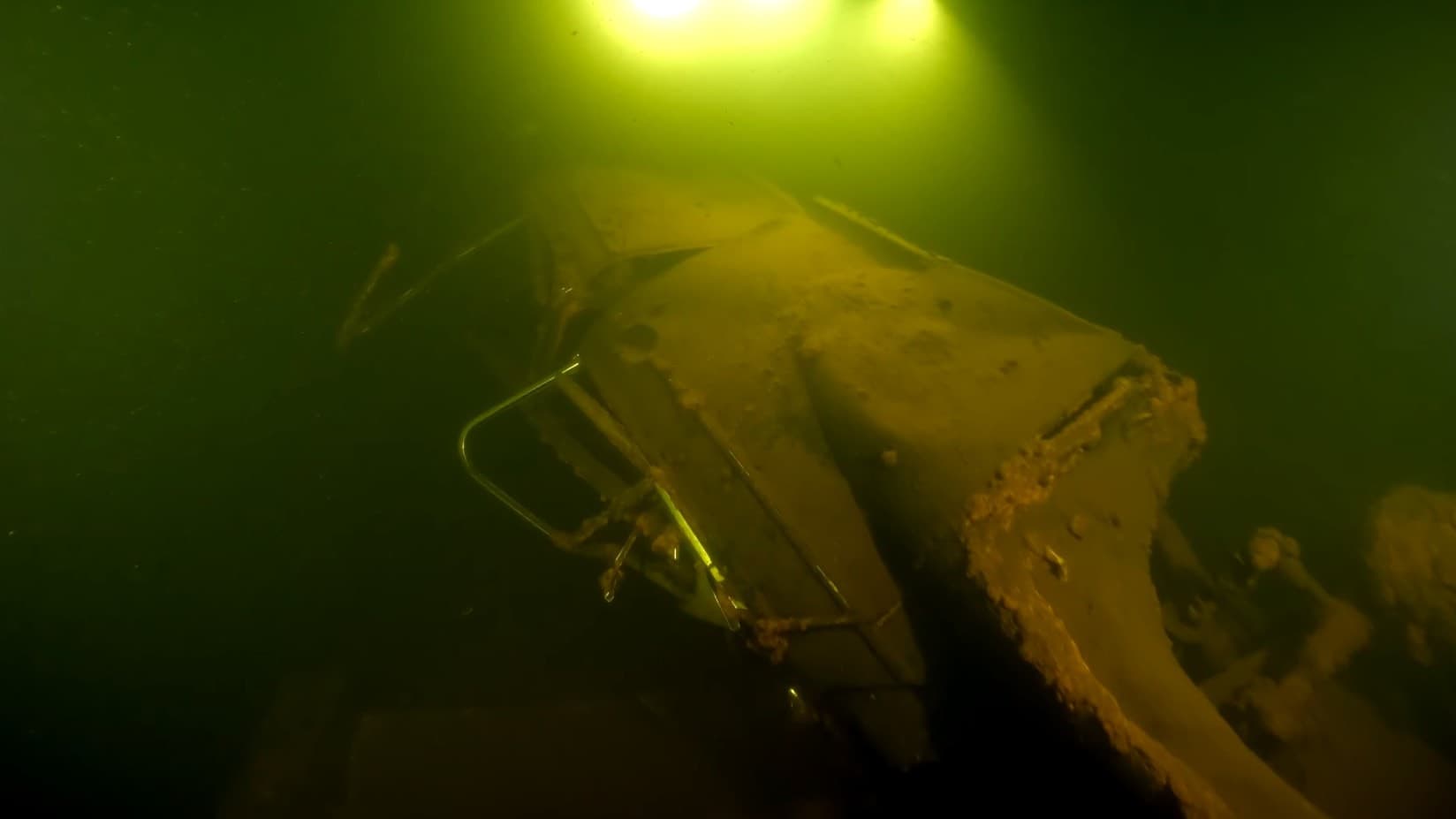 Under vattnet syns rester av en dränkt by i Njuoravuolle, Jokkmokks kommun, med en en gammal bil täckt av sediment. Bilden illustrerar forskarnas undersökningar av området.