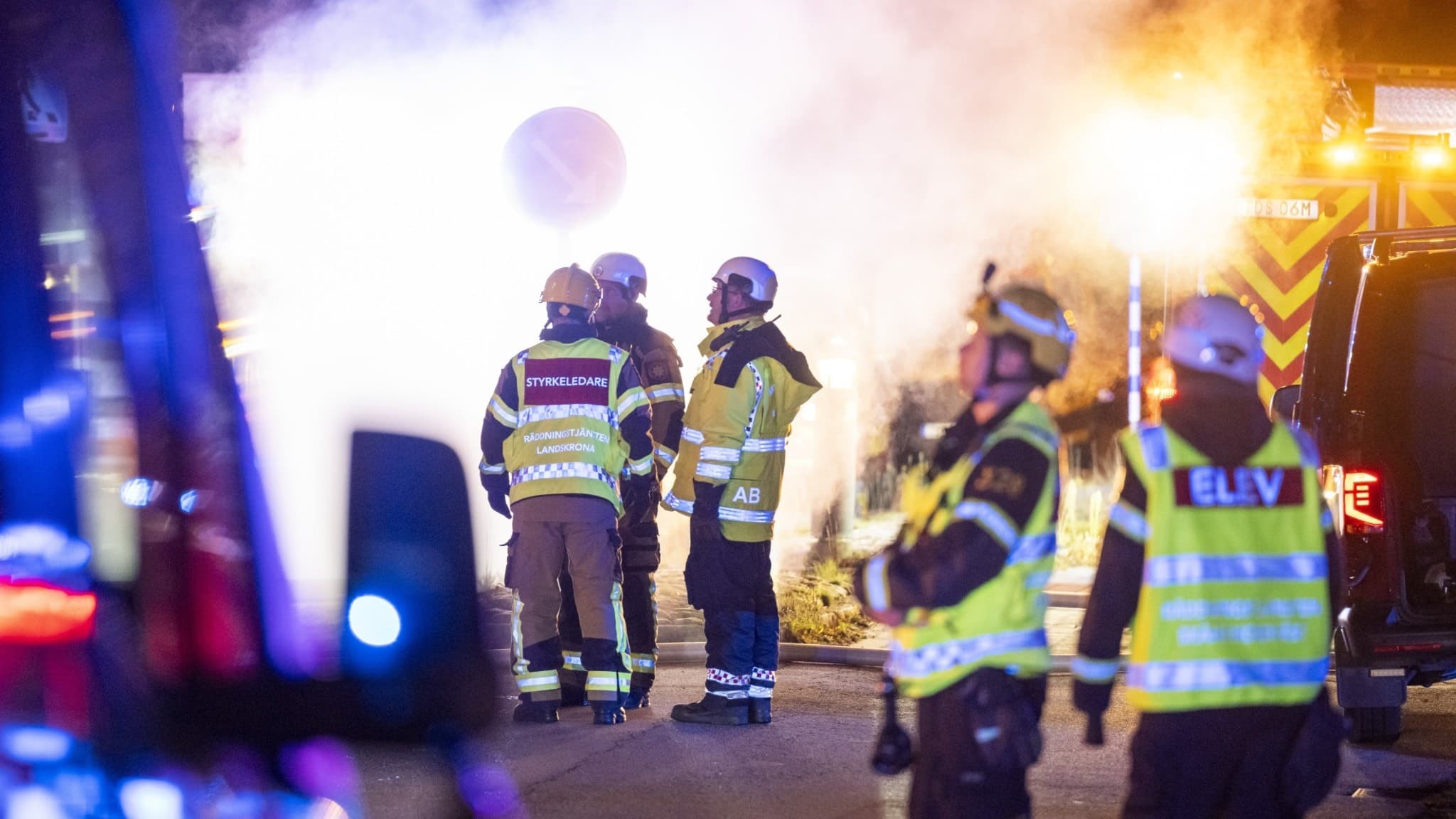 Brandmän bekämpar en eldsvåda i ett höghus på Pjäsgatan i Landskrona. Kraftig rök och flertalet utryckningsfordon syns på platsen. Räddningstjänsten arbetar intensivt under natten.