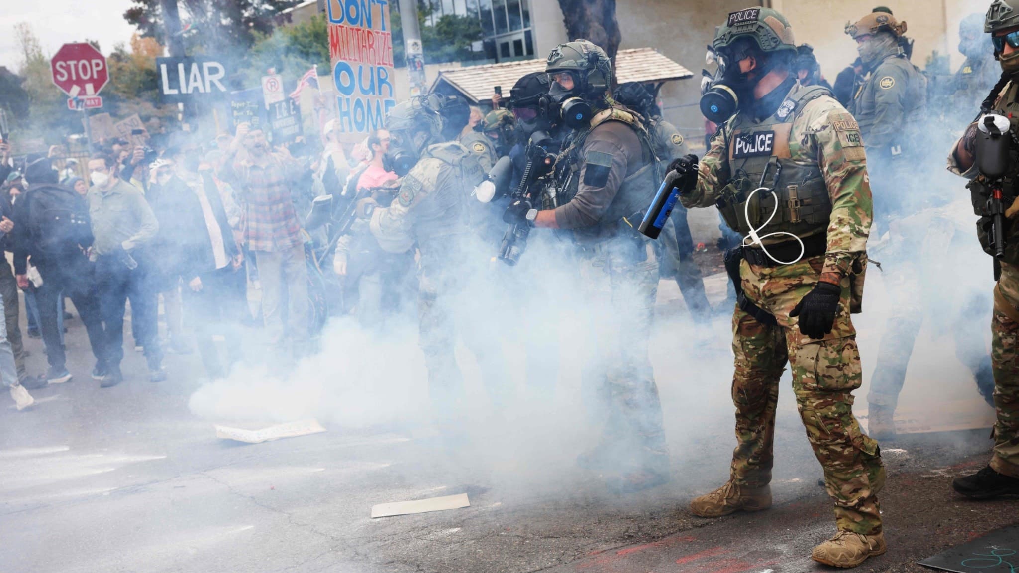 Federala agenter i taktisk utrustning står omgivna av tårgas under protester vid en ICE-anläggning i Portland, Oregon. 