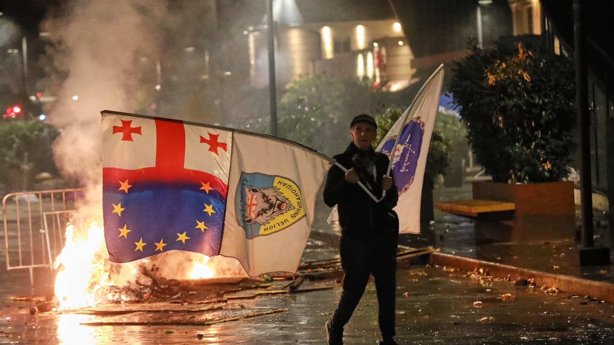 En man med en stor georgisk europeisk flagga