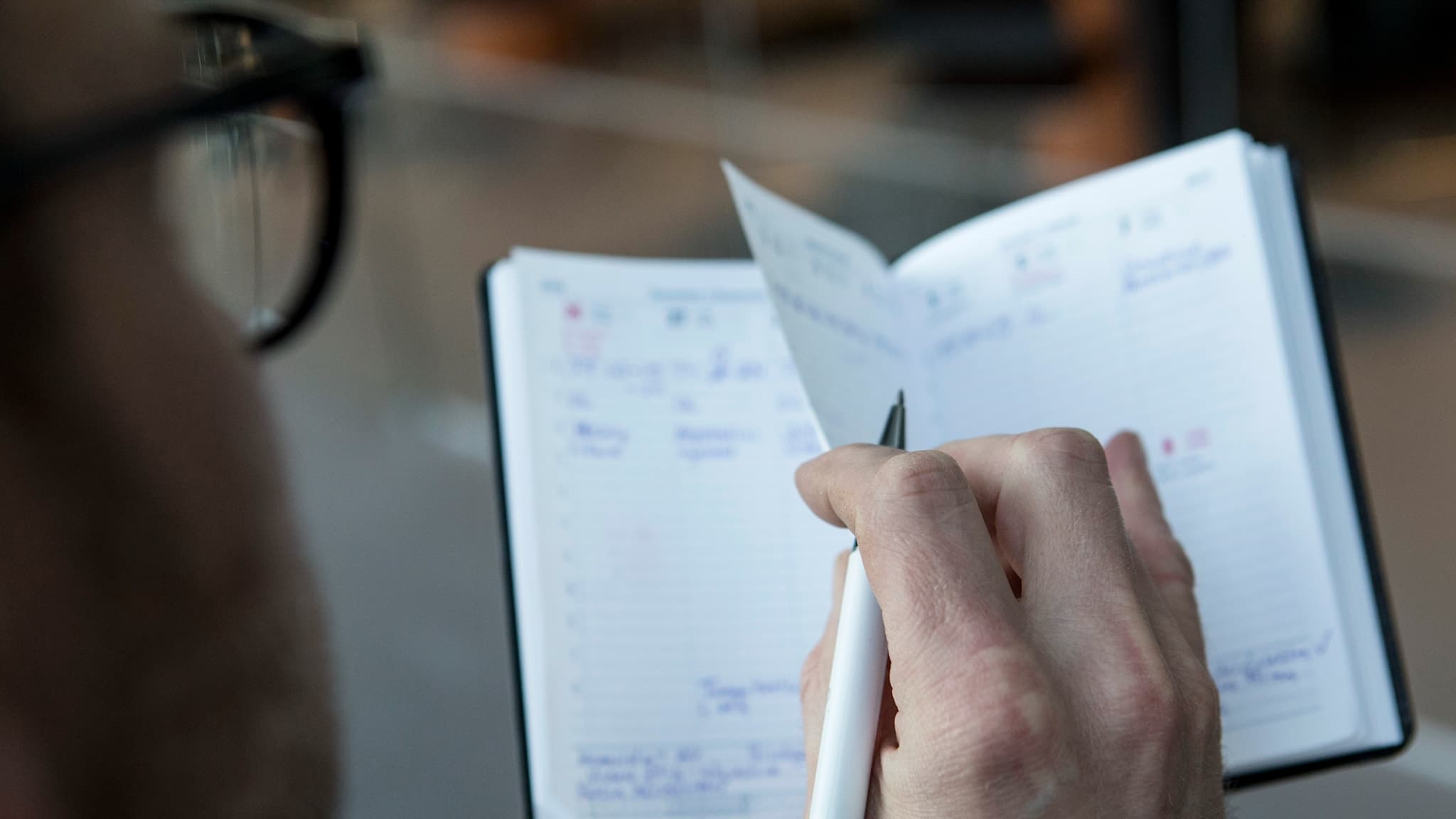 En kvinna bläddar i sin välfyllda kalender med en penna i handen. Foto: Christine Olsson/TT