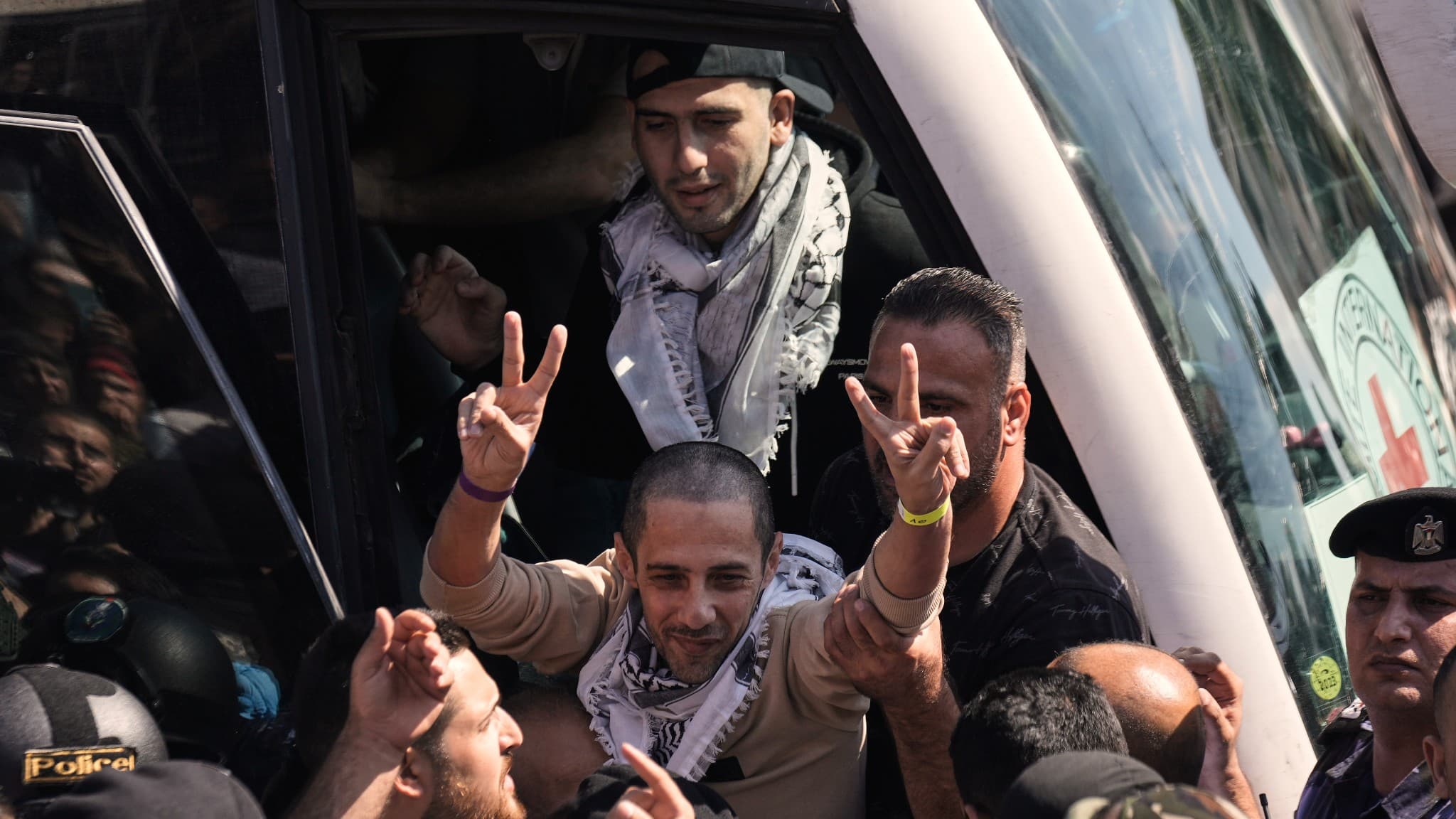 Flera palestinska män omfamnar och firar nyligen frigivna fångar i Ramallah, Västbanken.