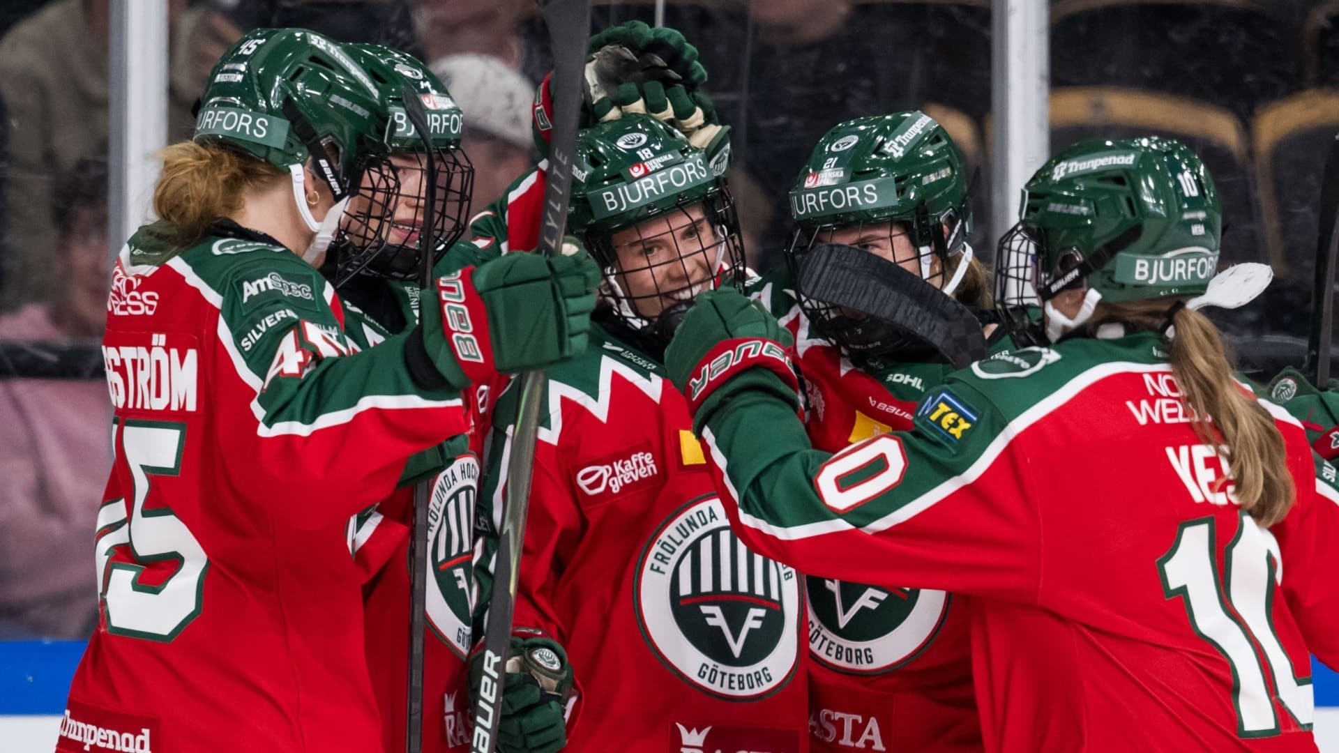 Hockeyspelare i röda tröjor kramas i en ring
